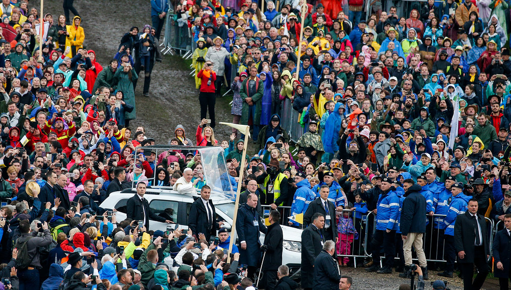 Menschen in bunten Regenjacken und mit Schirmen bei der Ankunft von Papst Franziskus im Papamobil zu einer Messe am 1. Juni 2019 im Marienwallfahrtsort Sumuleu Ciuc (Rumänien).
