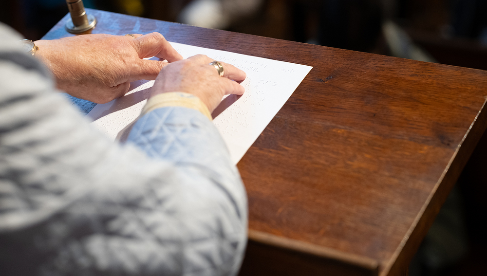 Blinde Lektorin liest Lesung mittels Braille-Schrift