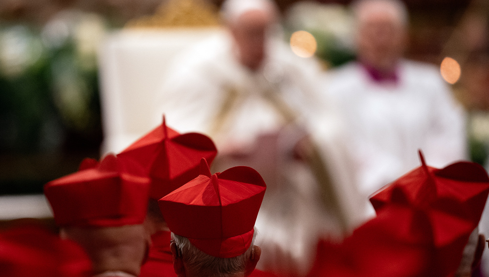 Kardinäle mit Birett und Papst Franziskus  im Hintergrund, im Petersdom beim Konsistorium 2024